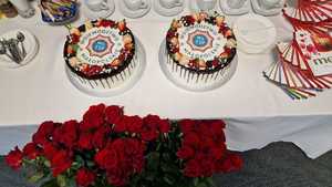 Na zdjęciu widać dwa torty, róże i poukładane bombonierki.