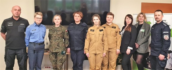Na zdjęciu widać przedstawicieli służb mundurowych w tym Policji, Wojska, Straży Pożarnej i Służby Więziennej oraz dwie kobiety w strojach cywilnych.